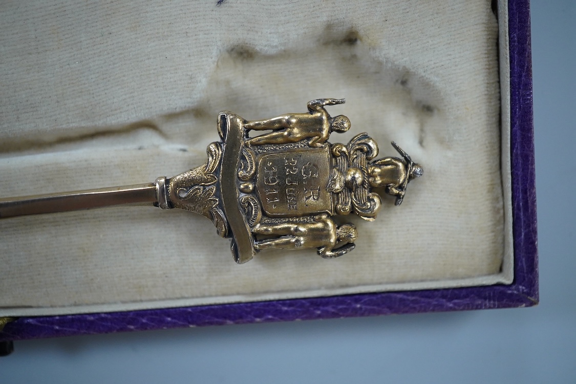 A cased silver gilt and polychrome enamelled spoon, the terminal modelled as the crest of the Worshipful Company of Joiners and Ceilers, to commemorate the Coronation of George V in 1911, Levi & Salaman, London, 1910, 17